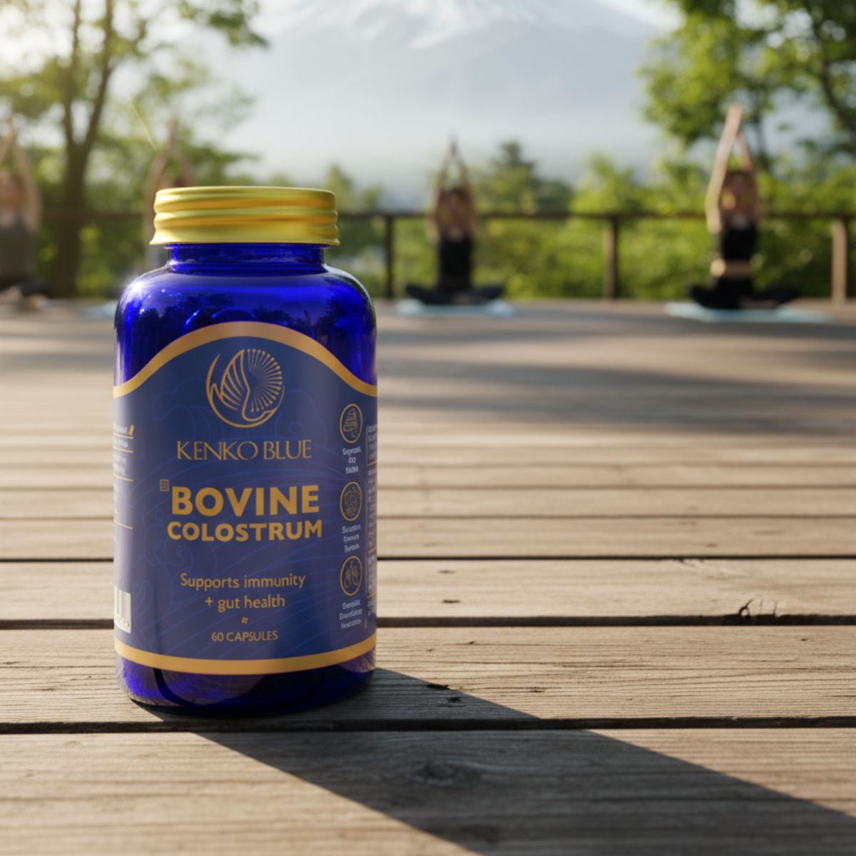 Bottle of Kenko Blue Bovine Colostrum on a wooden deck with people exercising in the background.