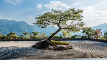 Zen garden with a tree and mountains in the background